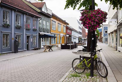 Toetasjers trehus i blått, grønt, gult, rødt og hvitt langs en folketom gågate