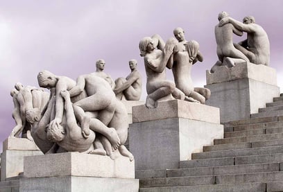 En samling av granittskulpturer av nakne mennesker i ulike aldre