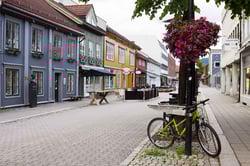 Toetasjers trehus i blått, grønt, gult, rødt og hvitt langs en folketom gågate