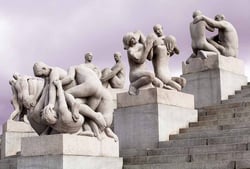 En samling av granittskulpturer av nakne mennesker i ulike aldre