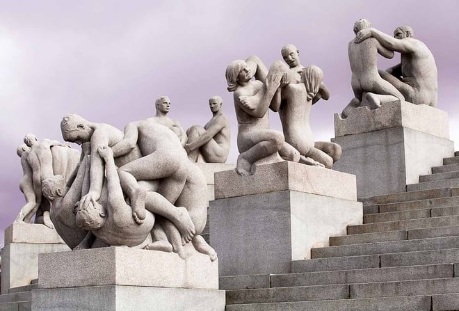 En samling av granittskulpturer av nakne mennesker i ulike aldre