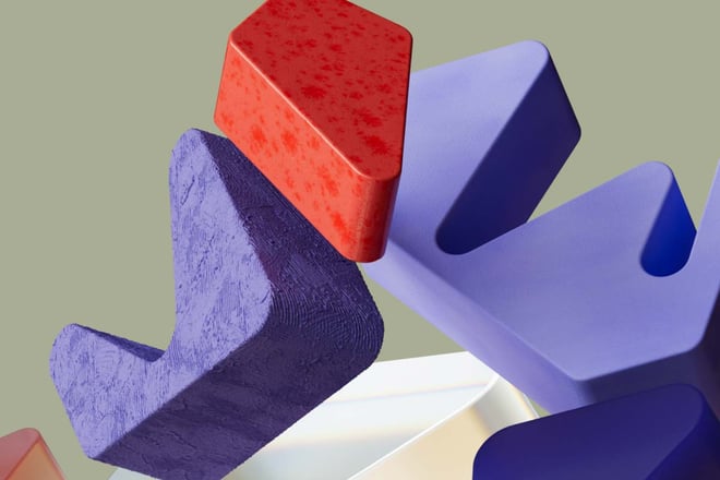 Nærbilde av abstrakte, tredimensjonale former stablet oppå hverandre: en rød, en lilla teksturert blokk, og en glatt lavendelfarget dubinsform. Bakgrunnen er beige.